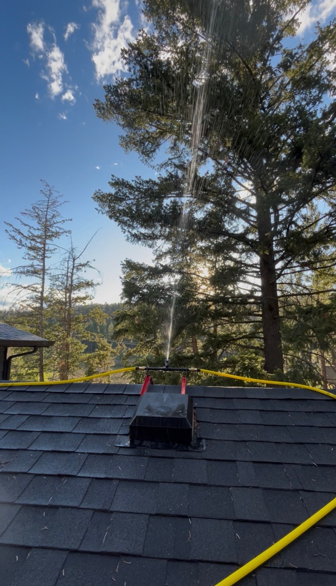 Peak-mounted wildfire sprinkler in action