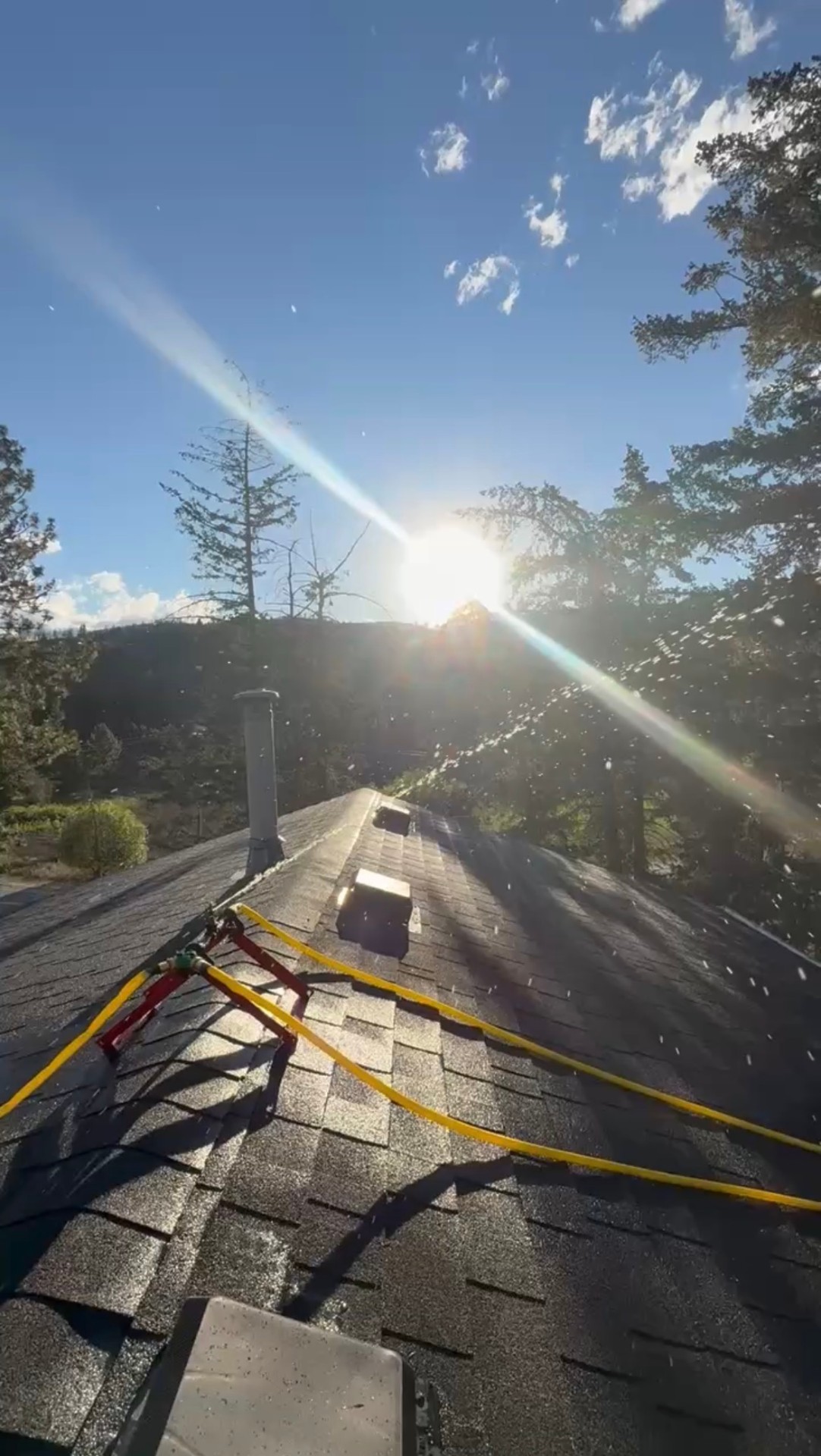 Rooftop sprinkler system spraying water at sunset
