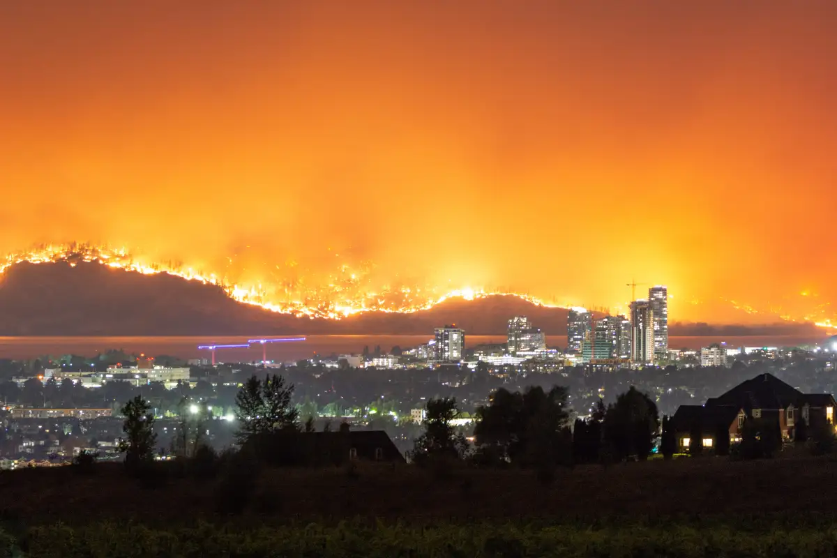 Wildfire burning on hillside above an Okanagan city at night
